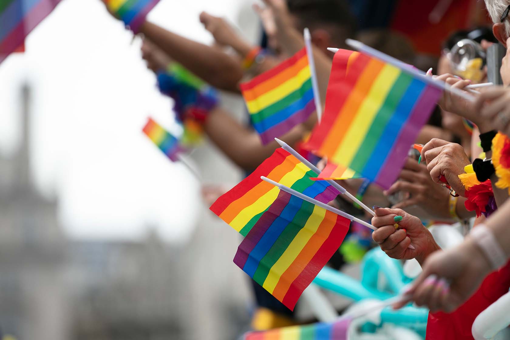 Rainbow flags being waved at a parade