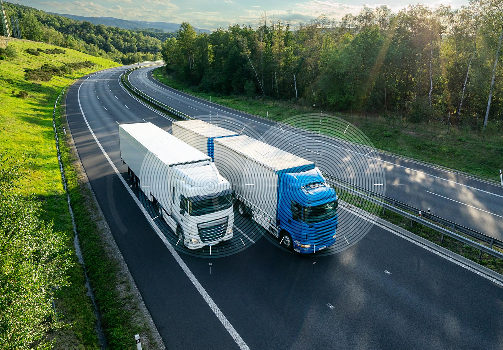 Two trucks side by side on a highway with circular graphics over each truck